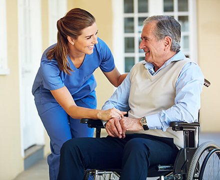 Nurse caring for a smiling man in a wheelchair
